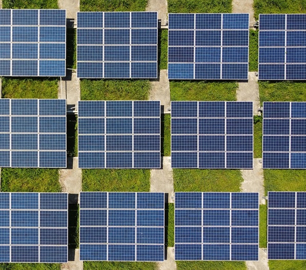 An array of solar panels on a grassy background.