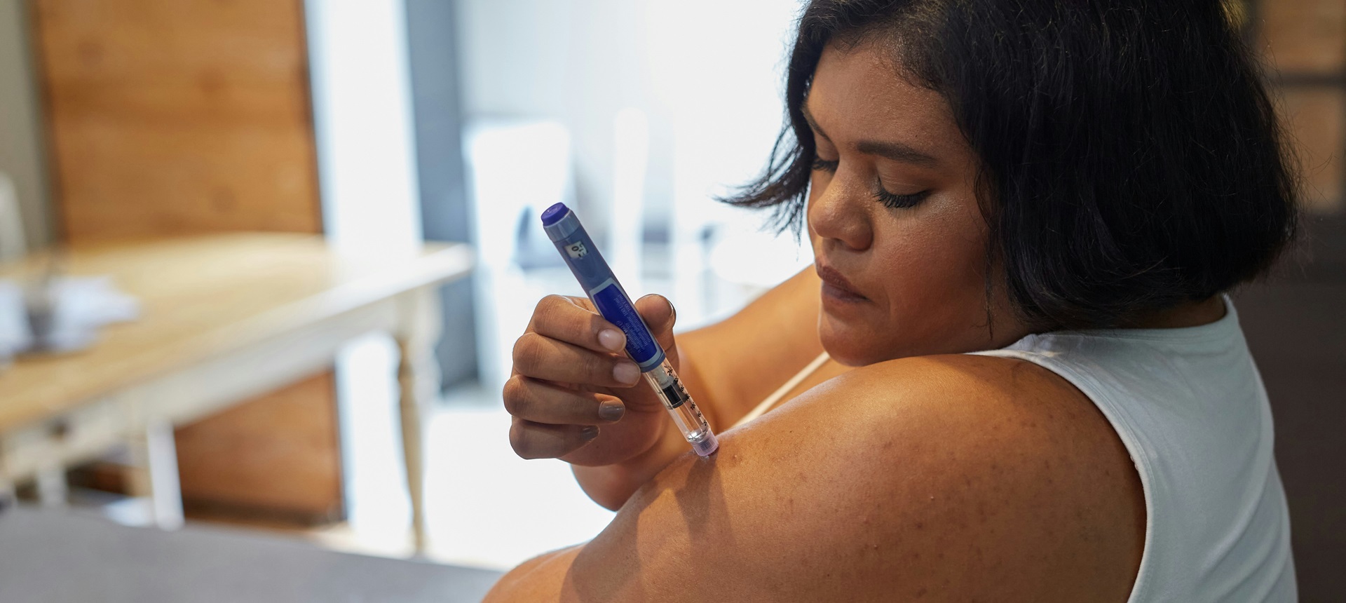 Young woman giving herself an insulin injection. Photo by Sweet Life on Unsplash