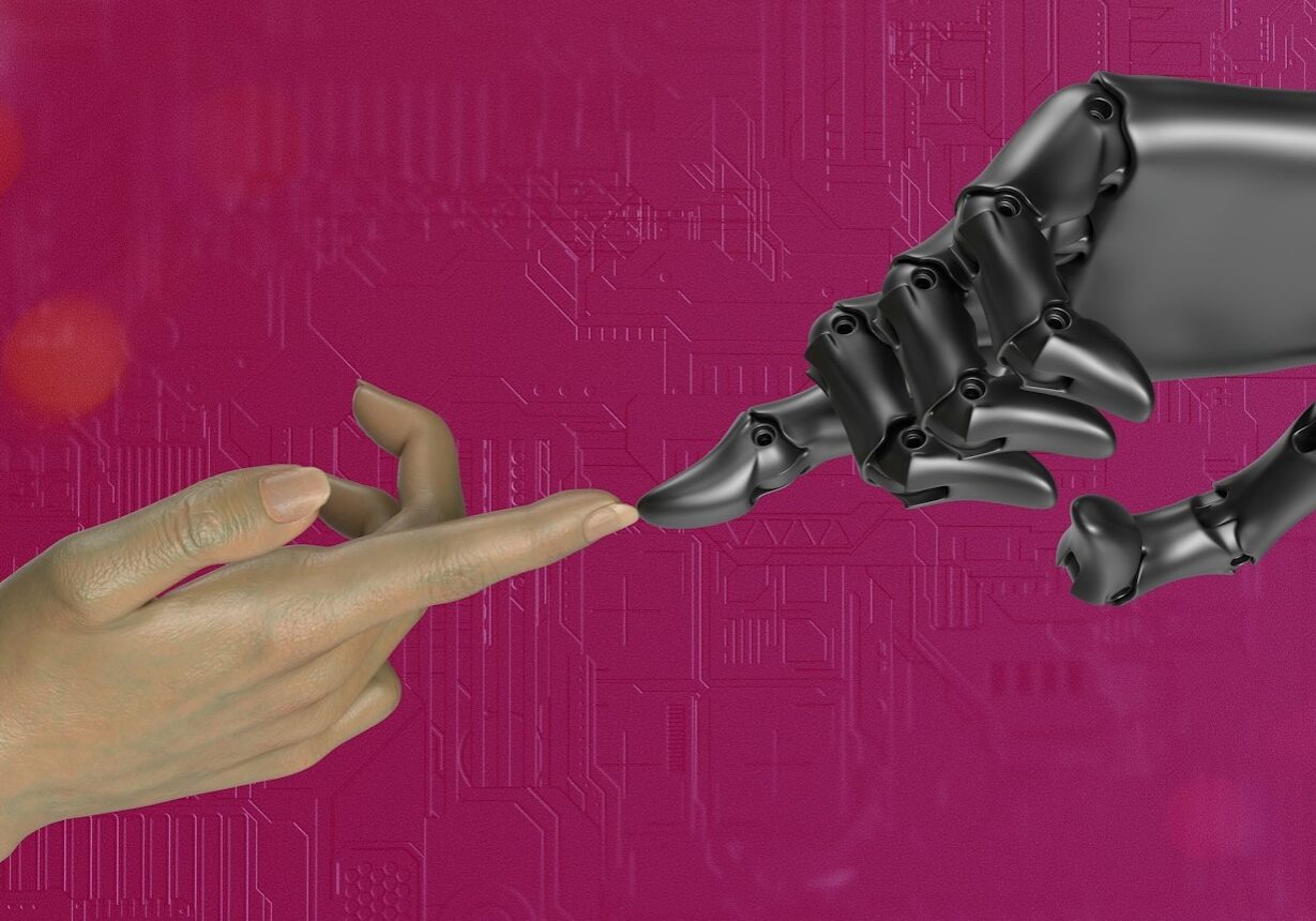 Human hand touching a robotic hand