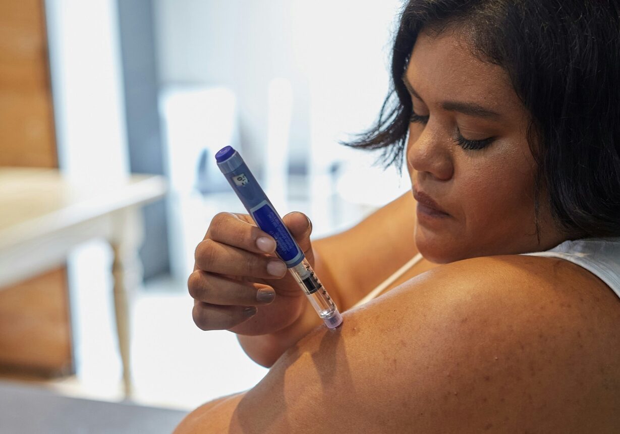 Young woman giving herself an insulin injection. Photo by Sweet Life on Unsplash